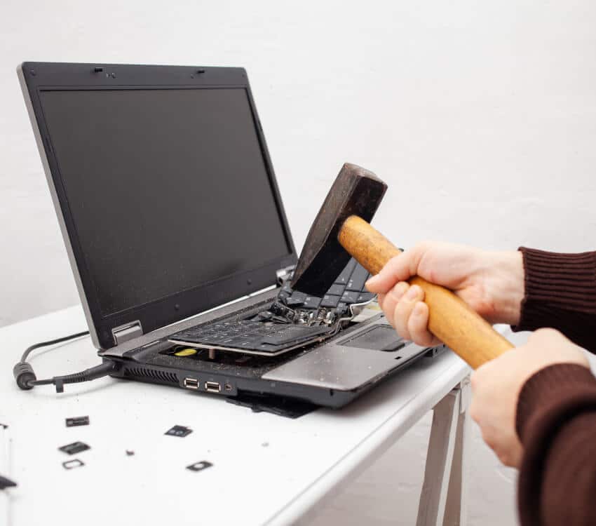 Frustrated Business Owner Smashing Laptop With A Hammer - They Wish They Used Fat Penguin Marketing